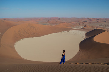Woman in Blue Onesie Standing on Dune Looking onto Sossusvlei Salt Pan, Desert Landscape, Namibia