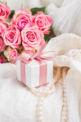 Female dress and jewellery with fresh roses flowers and present box close up