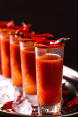 Bloody Mary cocktail with chili pepper, ice and celery.