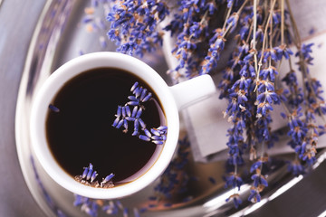 Cup of coffee with lavender flowers on table