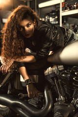 Obraz na płótnie Canvas Female mechanic repairing her motorcycle at her workshop