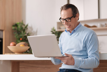 Aged freelancer using digital gadget at home