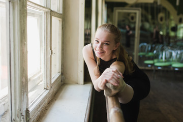 Young beautiful ballerina dancer warming up in ballet class. Girl stretching at ballet class