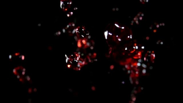 Close-up of Grape juice, red wine flies to the camera on a black background in slow motion