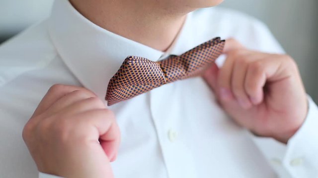 Man clothes a tie on white shirt.