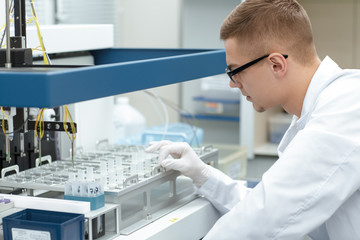 Naklejka premium Young male scientist working at the laboratory