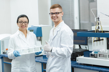 Senior female researcher and her young chemist colleague working together at the lab
