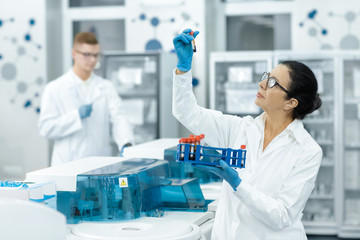 Senior woman professional chemist working with blood samples at the modern laboratory
