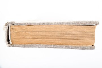 A vintage book in an old cloth cover lies on a white isolated background. Horizontal frame
