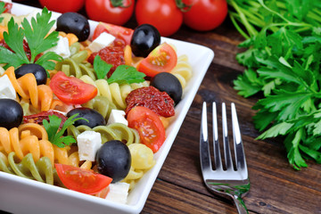 Pasta with vegetable in a plate and fork