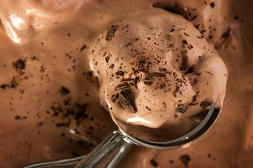 Tasty appetizing chocolate creamy ice cream with chocolate chunks in ice cream spoon. Horizontal with Copy Space.