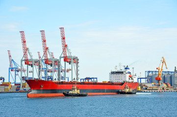 Tugboat assisting bulk cargo ship