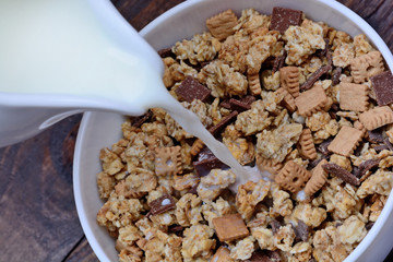 Milk pouring in a bowl with muesli