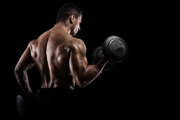 Fototapeta na wymiar Athletic man training biceps on black background
