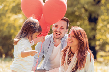 Smiling family picnicking in the park