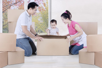 Asian family is unpacking boxes at home