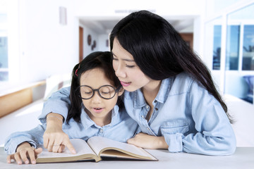 Child and her mother read a book