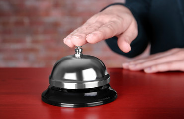 Woman ringing service bell in hotel lobby