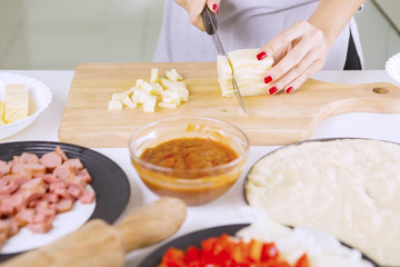 Female's hand cutting cheeses