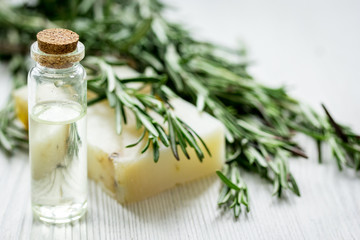 Fototapeta na wymiar cosmetic oil in bottle with herbs on light table background