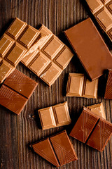 black and milk chocolate bars dark wooden table background top view