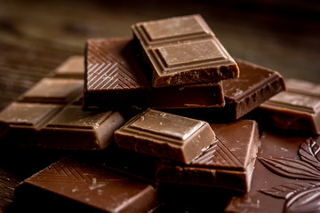 chopped chocolate pieces for dessert dark wooden desk background