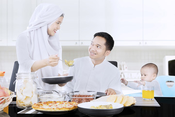 Muslim woman gives meal to husband