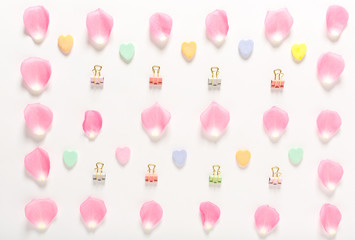 Candy hearts and rose petals on a white background