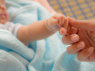 Baby hold one's hands his mother. The love of a mother concept.
