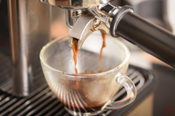 Fototapeta na wymiar Coffee flowing into a cup from espresso machine