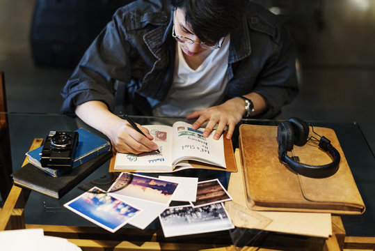 Young photographer writing diary and photobook
