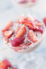Sweet dessert from cheese and yogurt with fresh ripe strawberry in a glass jar, on rustic wooden background. Selective focus