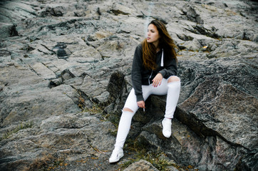 girl sits on the rocks, girl with a cigarette