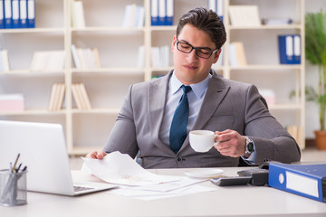Businessman spilling coffee on important documents
