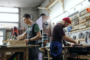 Fototapeta na wymiar Young professional carpenter working in the workshop