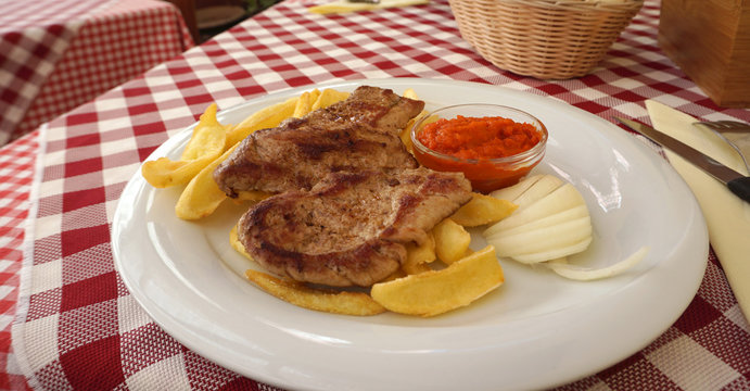 Porkchop with french fried serving with salsa dipping sauce