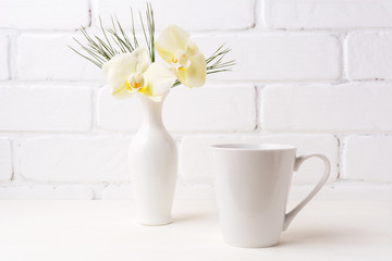 White coffee latte mug mockup with soft yellow orchid in vase