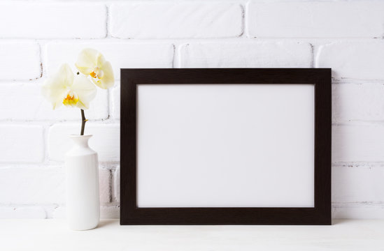 Black brown  landscape frame mockup with soft yellow orchid in vase