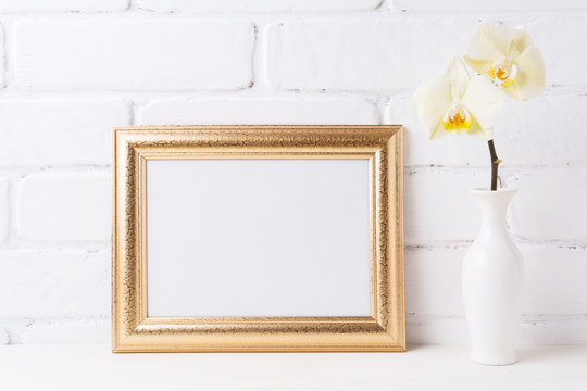 Golden  landscape frame mockup with soft yellow orchid in vase