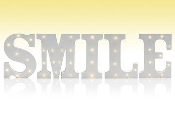 Illuminated Letters Spelling SMILE Over Gradient Yellow-White Background