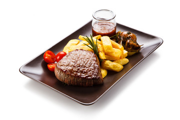 Grilled beefsteak with french fries and mushrooms on white background