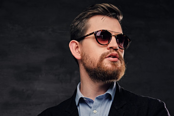 Fototapeta premium An elegant bearded male dressed in cotton velvet suit and sunglasses.
