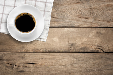 Top view of a white coffee cup on wood background with copy space.