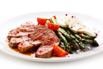 Grilled meat with asparagus and mozarella on white background