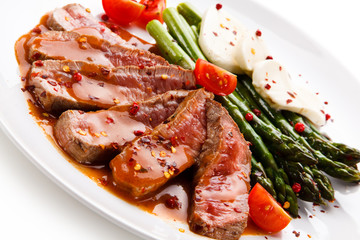 Grilled meat with asparagus and mozarella on white background