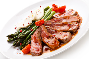 Grilled meat with asparagus and mozarella on white background