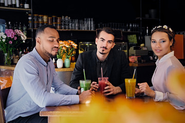 Friends drinking coctails in a cafe.