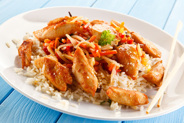 Grilled chicken strips with rice on blue planks