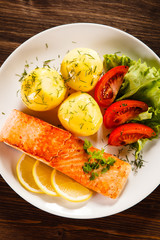 Grilled salmon with potatoes on wooden table