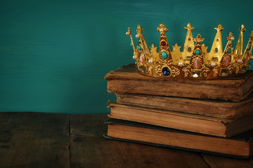 queen/king crown on old book. vintage filtered. fantasy medieval period